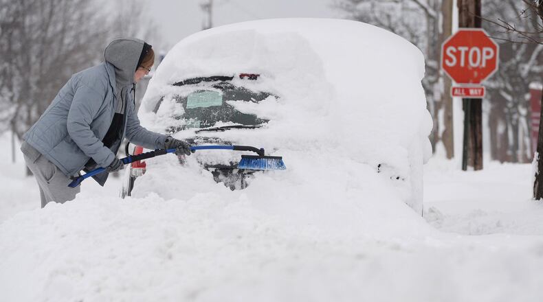 Chelse Volgyes clears snow from her car in Erie, Pa., Wednesday, Dec. 27, 2017. Freezing temperatures and below-zero wind chills socked much of the northern United States on Wednesday, and the snow-hardened city of Erie, dug out from a record snowfall.