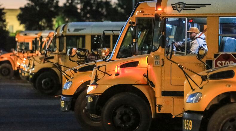 April 20, 2018 DeKalb County: A DeKalb County School District bus driver pulls out from a row of parked buses at the DeKalb County School District complex at 1701 Mountain Industrial Boulevard in Stone Mountain. JOHN SPINK/JSPINK@AJC.COM