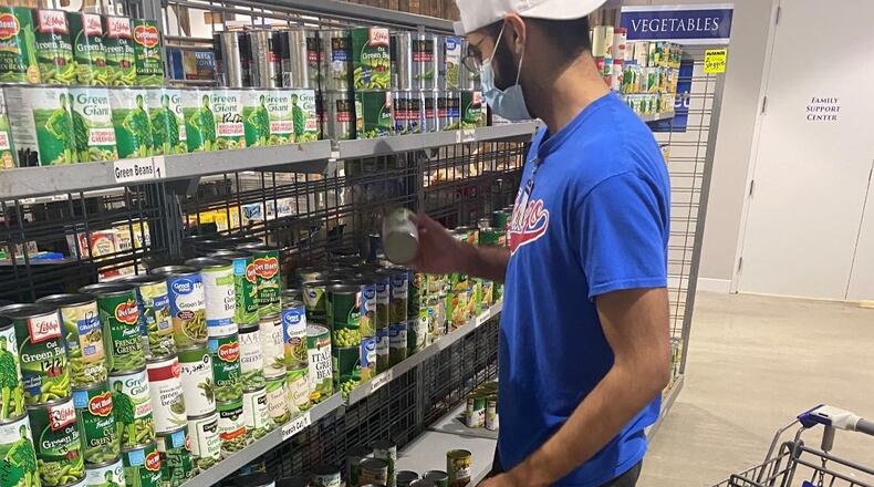 St. Vincent de Paul Georgia volunteers help organize the shelves at the organization's food pantry before clients arrive to shop. (Courtesy St. Vincent de Paul Georgia)