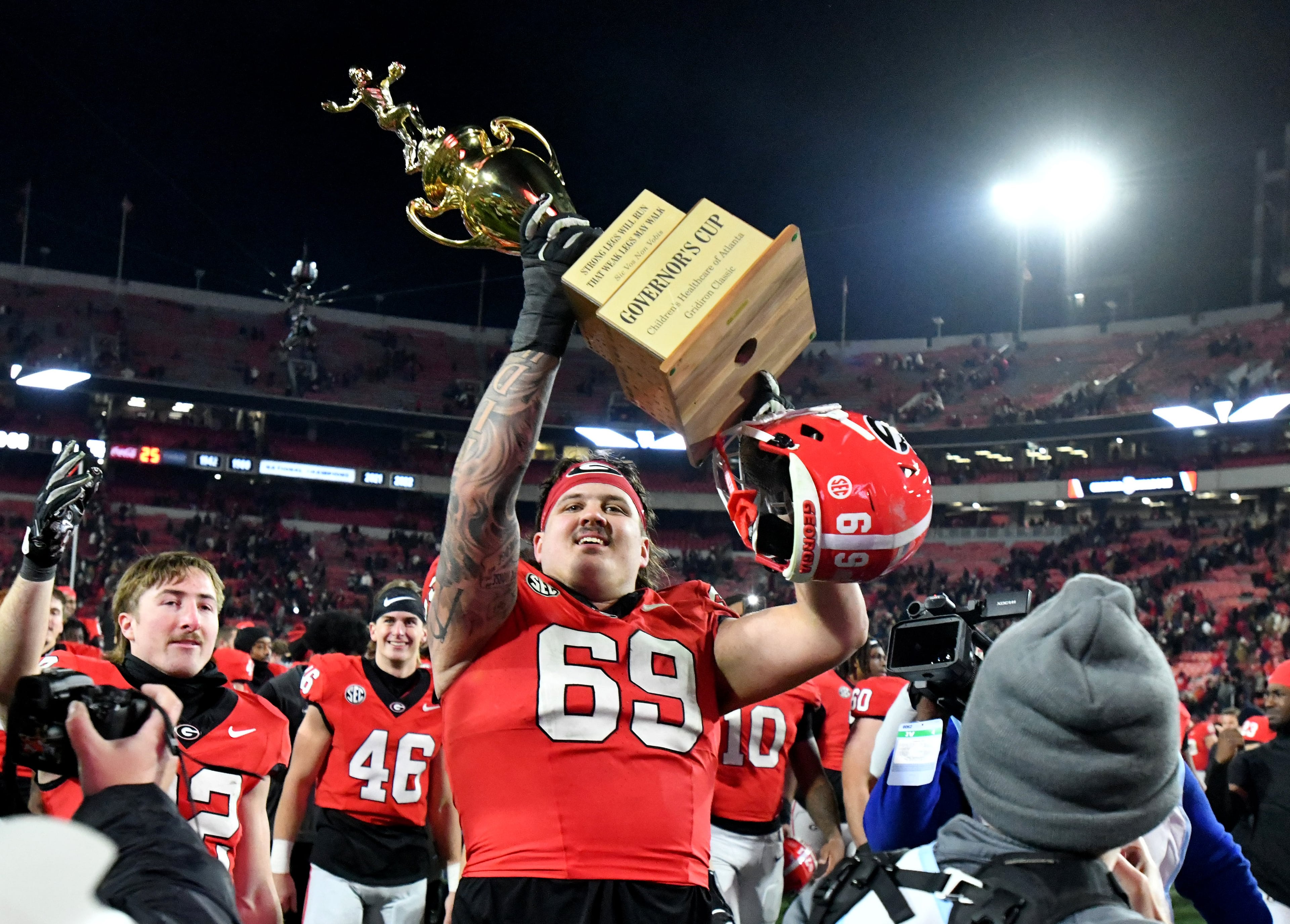 Georgia offensive lineman Tate Ratledge, now in the NFL, hoists the Governor's Cup trophy after the Bulldogs' eight-overtime win over Georgia Tech in 2024.