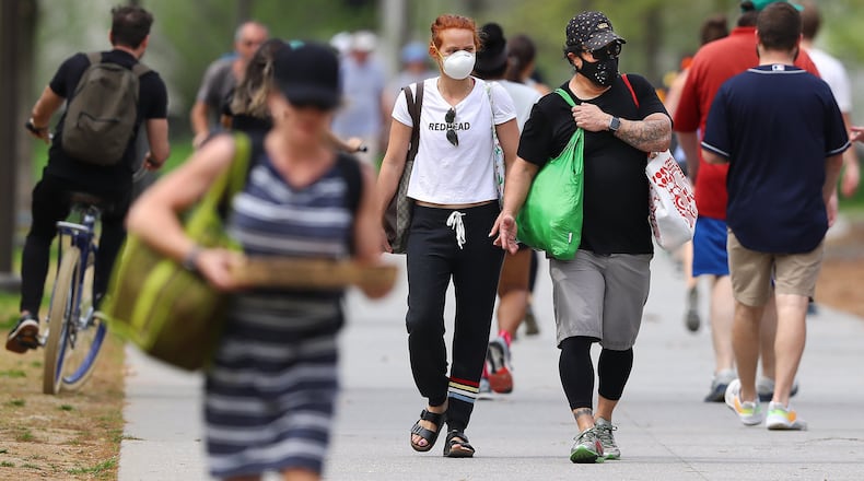 Rebecca Kenyon and Roger Mendoza both wear masks while making their way home on the Atlanta Beltline trail following a food run on March 29, 2020.