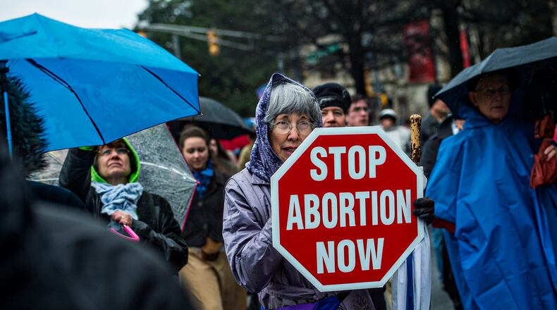 Janice McFarland (center) holds a pro life sign during the Georgia March for Life in Atlanta in January. Jonathan Phillips / For the AJC