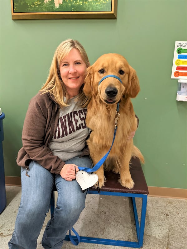 In this photo from 2022, provided by Helping Paws of Eden Prairie, Minn., state Rep. Melissa Hortman, DFL-Brooklyn Park, poses with Gilbert, a golden retriever trained to be a service dog but eventually adopted by the Hortman family, at a training facility in Hopkins, Minnesota. (Helping Paws via AP)
