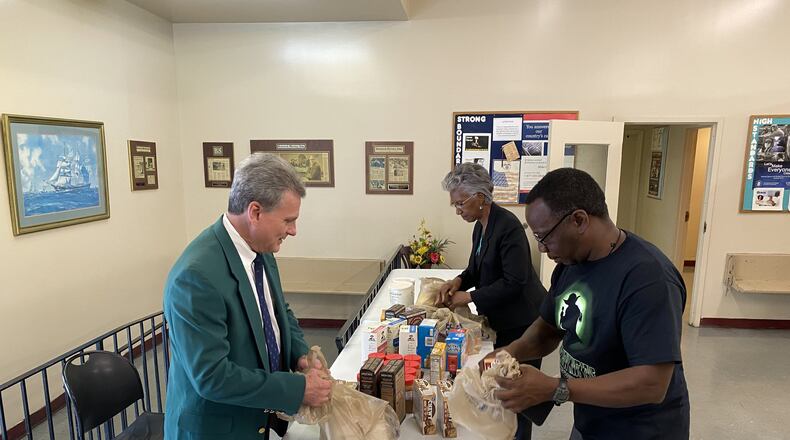 Republican U.S. Rep. Buddy Carter of Pooler, left, helps distribute food at the Old Savannah City Mission. (Photo provided by Carter’s office.)