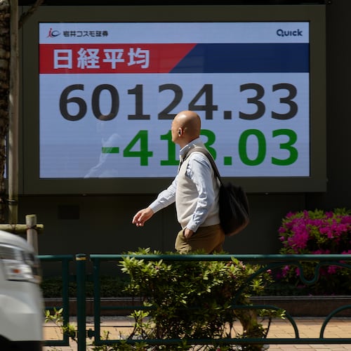 A person walks in front of an electronic stock board showing Japan's Nikkei index at a securities firm, Tuesday, April 28, 2026, in Tokyo. (AP Photo/Eugene Hoshiko)
