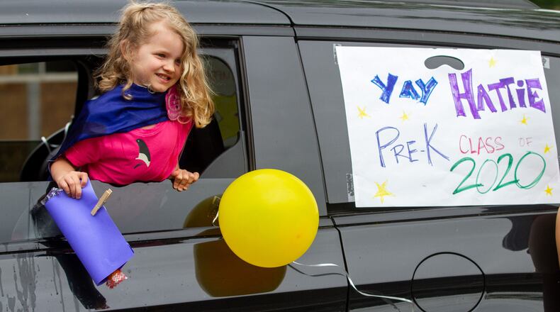 Often forgotten is how America's children bore many of the country's sacrifices in the battle against COVID-19. They’ve sat out of proms, kindergarten graduations, field trips, and even for some, being in the schoolhouse in its entirety. Here, Hattie McSherry holds her diploma during the Ormewood School's pre-K drive-by graduation on Wednesday, May 13, 2020. (Steve Schaefer / Steve.Schaefer@ajc.com)