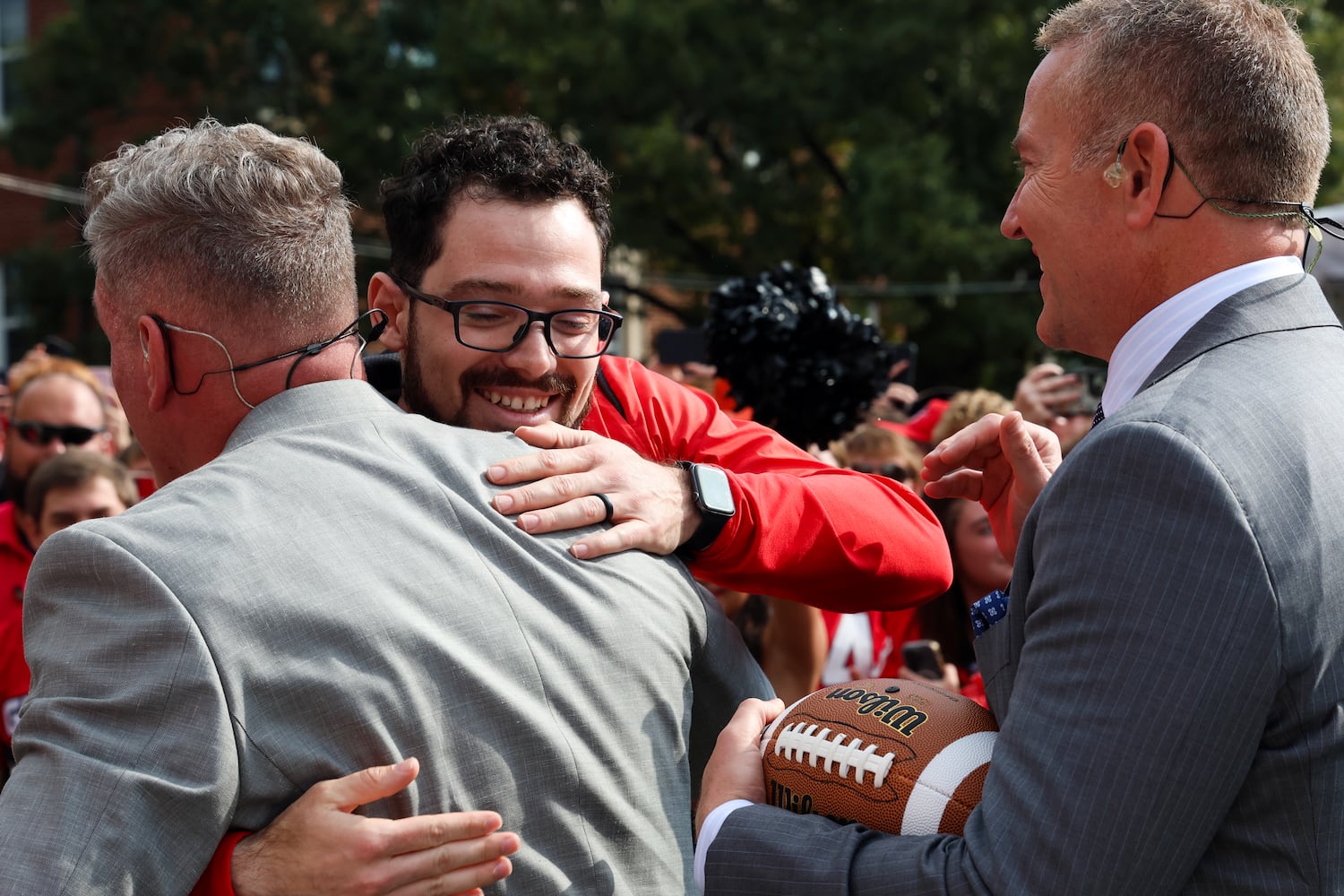 Former UGA kicker Rodrigo Blankenship (center) hugs Pat McAfee while Kirk Herbstreit (right) looks on during Pat McAfee’s Kicking Contest on the ESPN College GameDay broadcast from Myers Quad at UGA on Saturday, Oct. 18, 2025. (C.J. Bartunek for the AJC)

