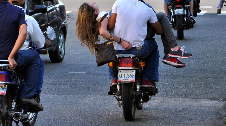 Genesis Carmona is driven away on a motorcycle after she was wounded during an anti-government protest in Valencia, Venezuela, Tuesday, Feb. 18, 2014. Carmona was allegedly struck by a bullet Tuesday when unknown gunmen on motorcycles opened fire on opposition protesters, said Enzo Scrano, mayor of a Valencia district. According to Scrano, Carmona, a 22-year-old university student, who is a former Miss Tourism for the northern state of Carabobo, died from her wounds on Wednesday, Feb. 19, 2014.