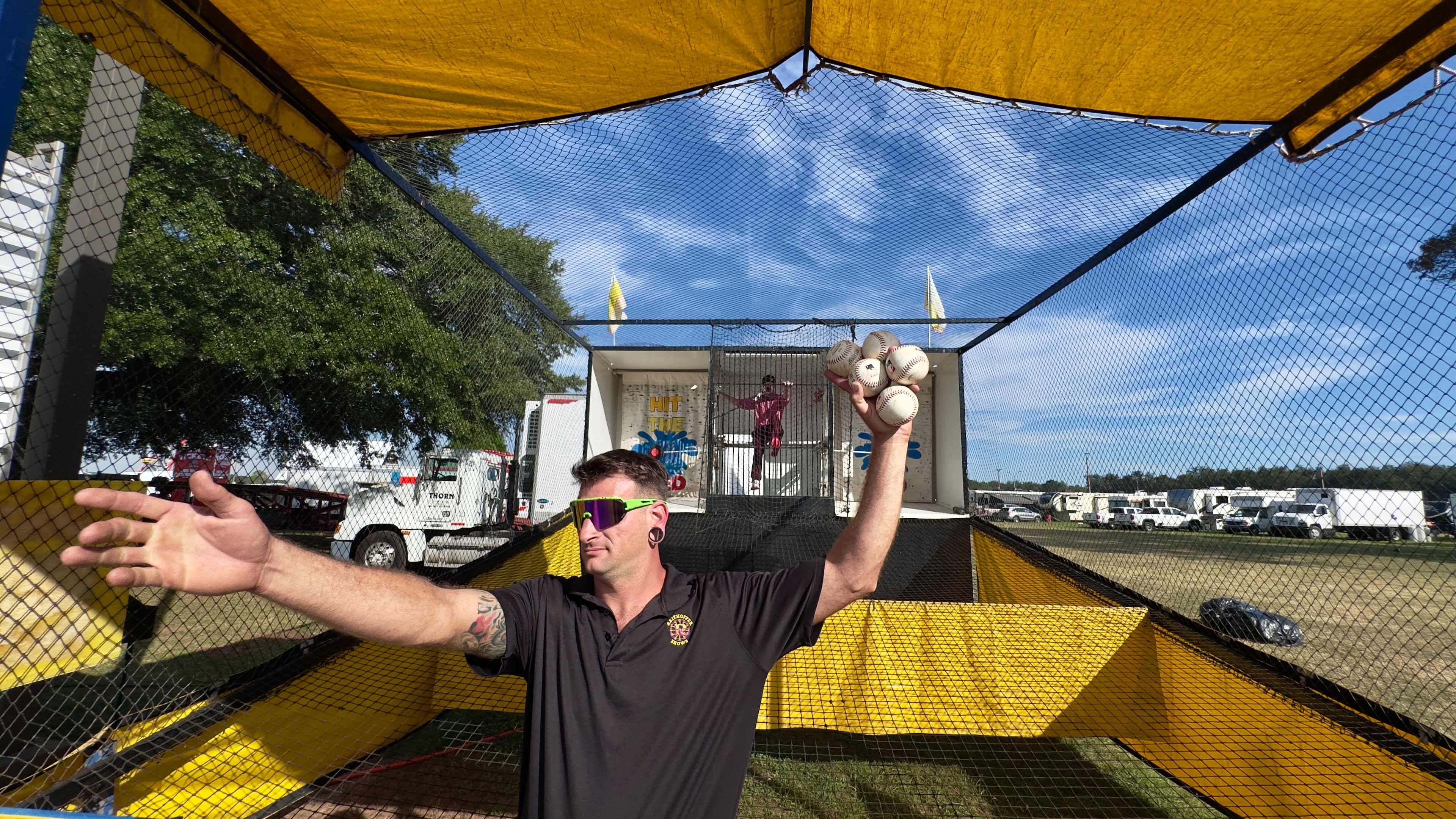 Gary Zack hawks baseballs to toss at the Georgia National Fair's dunking-booth clown. Zack also works as the booth's main clown act. Balls sell for $5 for five tosses and $10 for 12. (Joe Kovac Jr./AJC)