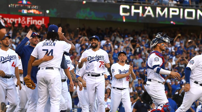 Los Angeles Dodgers players celebrate after securing the National League West division title with Monday's win over Colorado. (Photo by Jayne Kamin-Oncea/Getty Images)