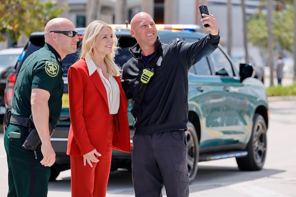 A Broward Sheriff's Deputy and a member of BSO Fire Rescue take a selfie with U.S. Attorney General Pam Bondi as she leaves a news conference after announcing the seizure of illegal narcotics on vessels headed for the U.S., Wednesday, April 9, 2025 at Port Everglades, Fla. (Amy Beth Bennett /South Florida Sun-Sentinel via AP)
