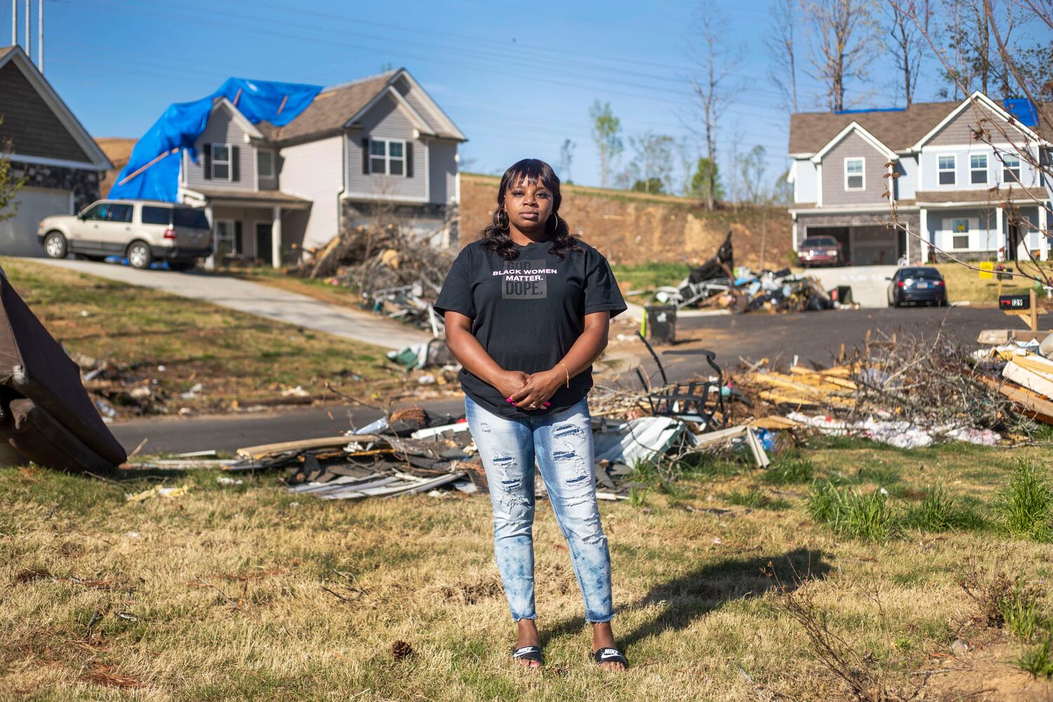 Brittany Mitchell, 30, stands in the midst of damage from an EF4 tornado that ripped through her neighborhood in March and damaged her family’s Newnan home. (Alyssa Pointer / Alyssa.Pointer@ajc.com)