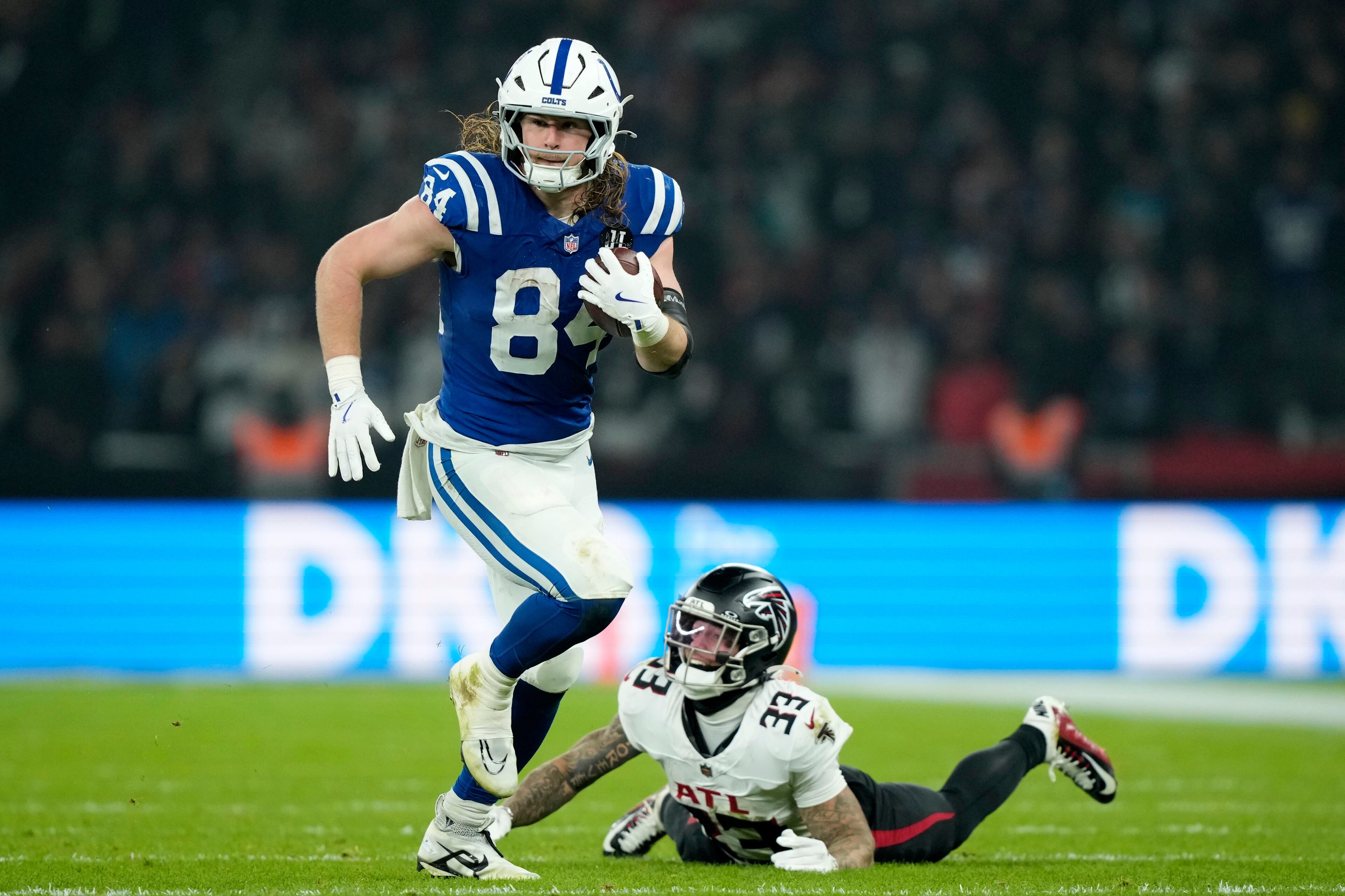 Indianapolis Colts tight end Tyler Warren (84) runs from Atlanta Falcons safety Billy Bowman Jr. (33) after catching a pass during the second half of an NFL football game, Sunday, Nov. 9, 2025, in Berlin, Germany. (AP Photo/Ebrahim Noorozi)