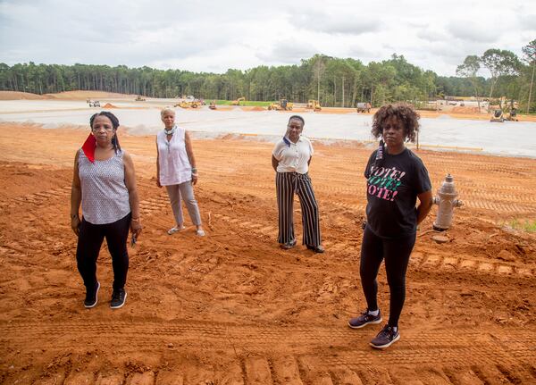 Residents of the subdivision Windsor Downs (from left) Renee Cail, Jake Bryant, Jennifer Wilson and Pyper Bunch, stand at the construction site of a recycling plant across the street from their  neighborhood on Friday, July 24, 2020. (Steve Schaefer/AJC 2020)