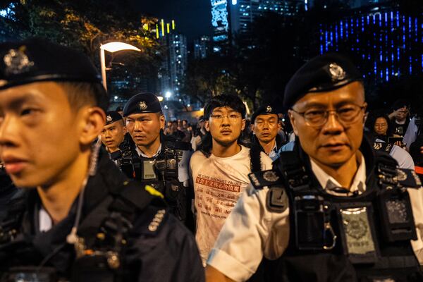 A man, center, is escorted by police officers at the Victoria Park, the city's venue for the annual 1989 Tiananmen massacre vigil, on the 36th anniversary of China's Tiananmen Square crackdown, in Hong Kong, Wednesday, June 4, 2025. (AP Photo/Chan Long Hei)