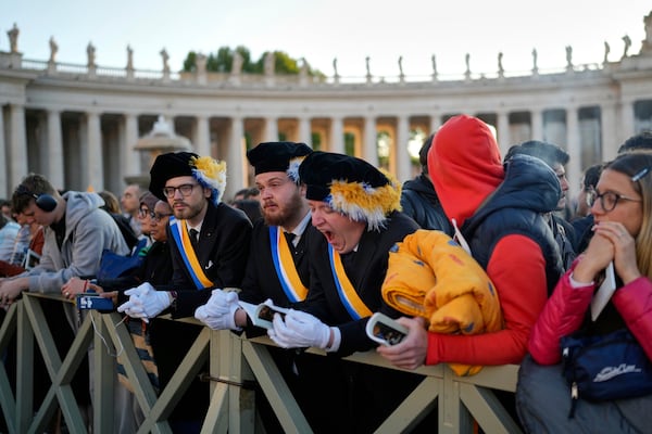 A man yawns as people arrive St. Peter's Square ahead of the funeral of Pope Francis at the Vatican, Saturday, April 26, 2025. (AP Photo/Andreea Alexandru)