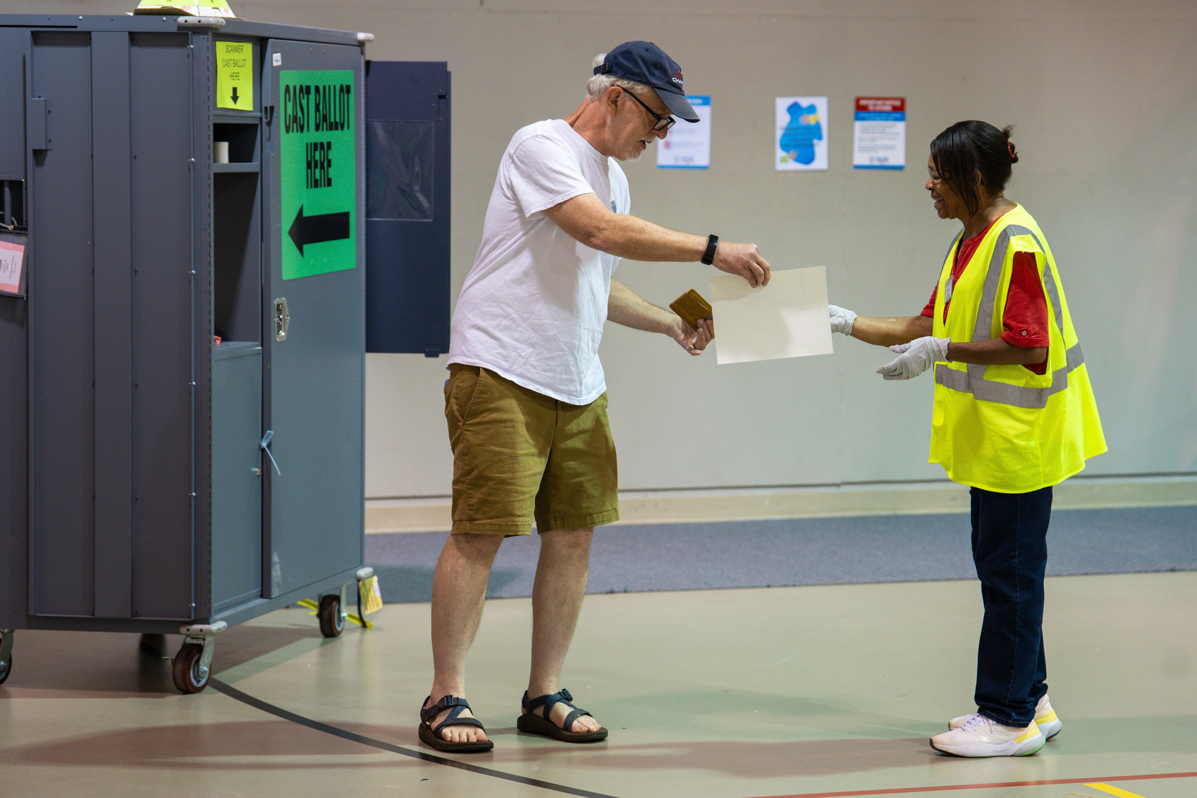 At a polling place in Cobb County, a voter turns in his ballot during the Democratic primary runoff for Georgia’s Public Service Commission on Tuesday, July 15, 2025. (Olivia Bowdoin/AJC)