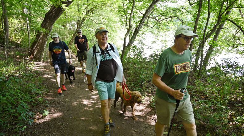 Members of the Trailheads (from left) George Hirthler, Brad Copeland with his dogs Elvis and Nilla, Guy Tucker with his dog Fio, and Patrick Scullin hike at Island Ford Park along the Chattahoochee River. (Hyosub Shin / Hyosub.Shin@ajc.com)