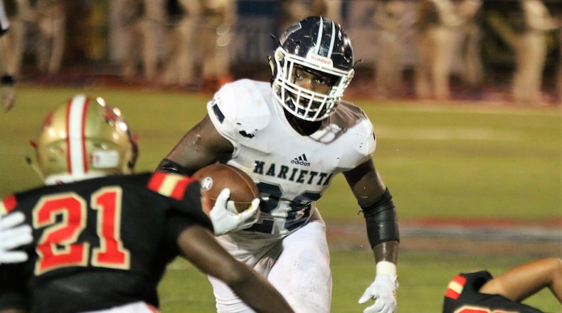 Marietta's Kimani Vidal runs the ball down field toward Rome's Trey Lawrence during the second quarter of Thursday's game at Barron Stadium in Rome.