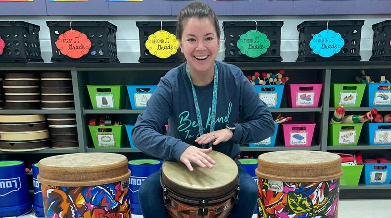 Ocee Elementary music teacher Damarys  Klausman is flanked by two tubano drums. A recent grant will add more of the tall instruments to her classroom.