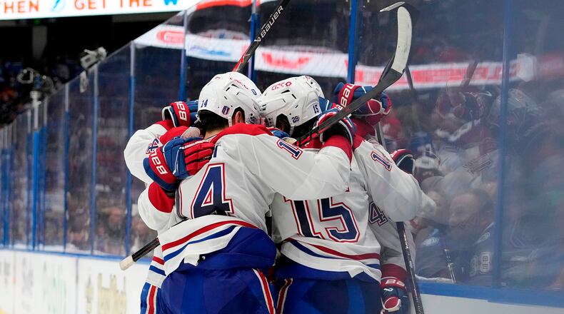 Montréal Canadiens center Alex Newhook (15) is mobbed by teammates, including Nick Suzuki (14) after scoring against the Tampa Bay Lightning during the third period in Game 7 of an NHL hockey Stanley Cup first-round playoff series, Sunday, May 3, 2026, in Tampa, Fla. (AP Photo/Chris O'Meara)