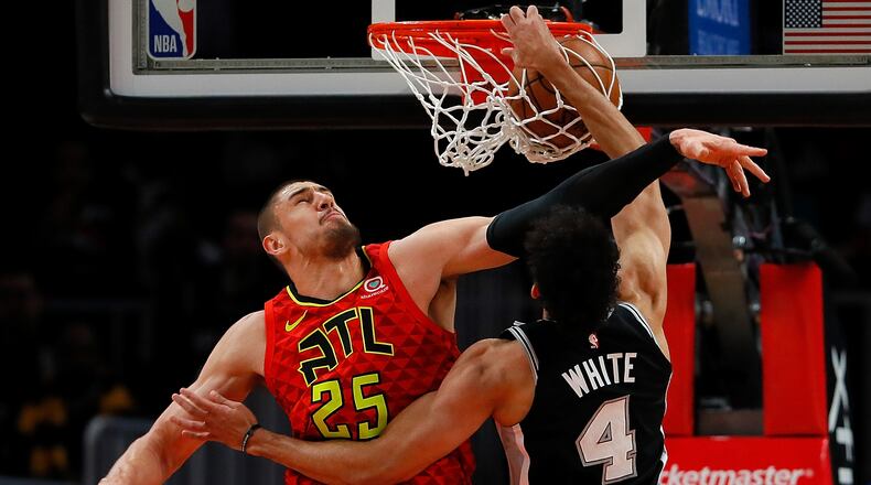 Derrick White of the San Antonio Spurs dunks against Alex Len of the Hawks at State Farm Arena on March 06, 2019 in Atlanta. (Photo by Kevin C. Cox/Getty Images)