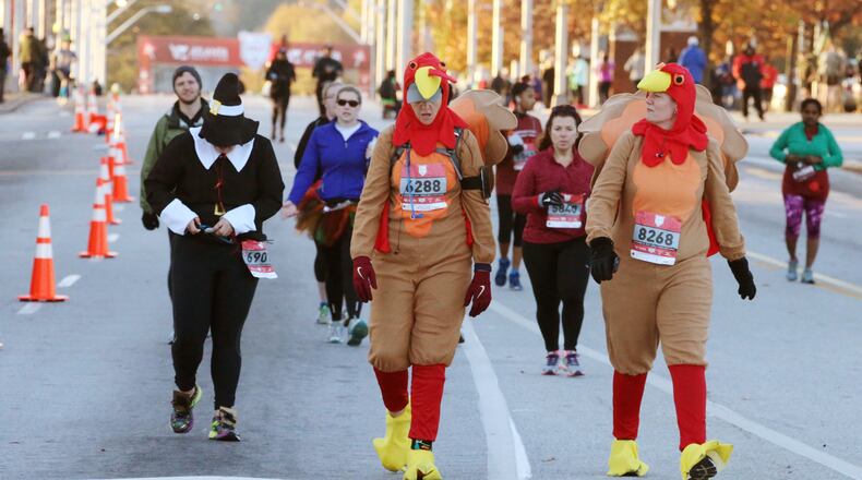 Sara Haskew (left), from Atlanta, and Christina Watts, from Decatur went full turkey Thursday morning to take part in the Thanksgiving Day Half Marathon events in downtown Atlanta. The half marathon, 5K, one mile and 50-meter dash started and finished at Turner Field. Geraint Davis of Suwanee, who was last year's second-place finisher, won the half marathon with a time of 1:10:54. Jill Braley of Rome broke the tape for the women in 1:18:47. She was also the female champion in 2013. BOB ANDRES / BANDRES@AJC.COM