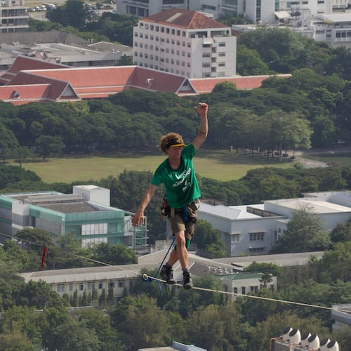 FILE - U.S. slackliner Andy Lewis of Calif. balances on a slackline in Bangkok, Thailand, July 23, 2014. (AP Photo/Sakchai Lalit, File)