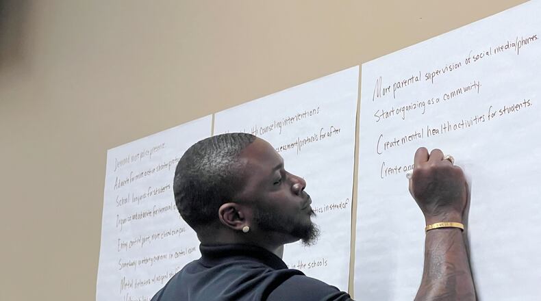 Brandon Jones with Skrews 4 Life records input as community members gather Thursday night, Feb. 8, 2024, at Patricia C. Vaughn Cultural Arts Center in Powder Springs to discuss safety concerns and possible solutions in the wake of last week's shooting at McEachern High School in Cobb County. (Cassidy Alexander / Cassidy.Alexander@ajc.com)