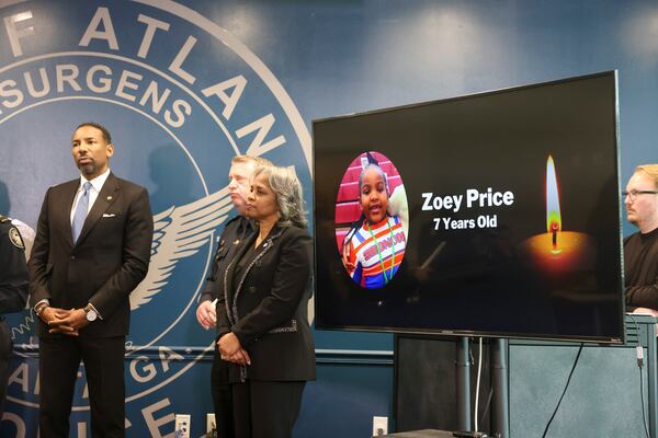 Atlanta Mayor Andre Dickens, left, listens next to an image of seven-year-old Zoey Price during a press conference, at Atlanta Public Safety Headquarters, Tuesday, March 3, 2026, in Atlanta. Officials provided an update on the fatal shooting of Zoey Price, 7, who was killed Feb. 24 in a shooting in northwest Atlanta. (Jason Getz/AJC)