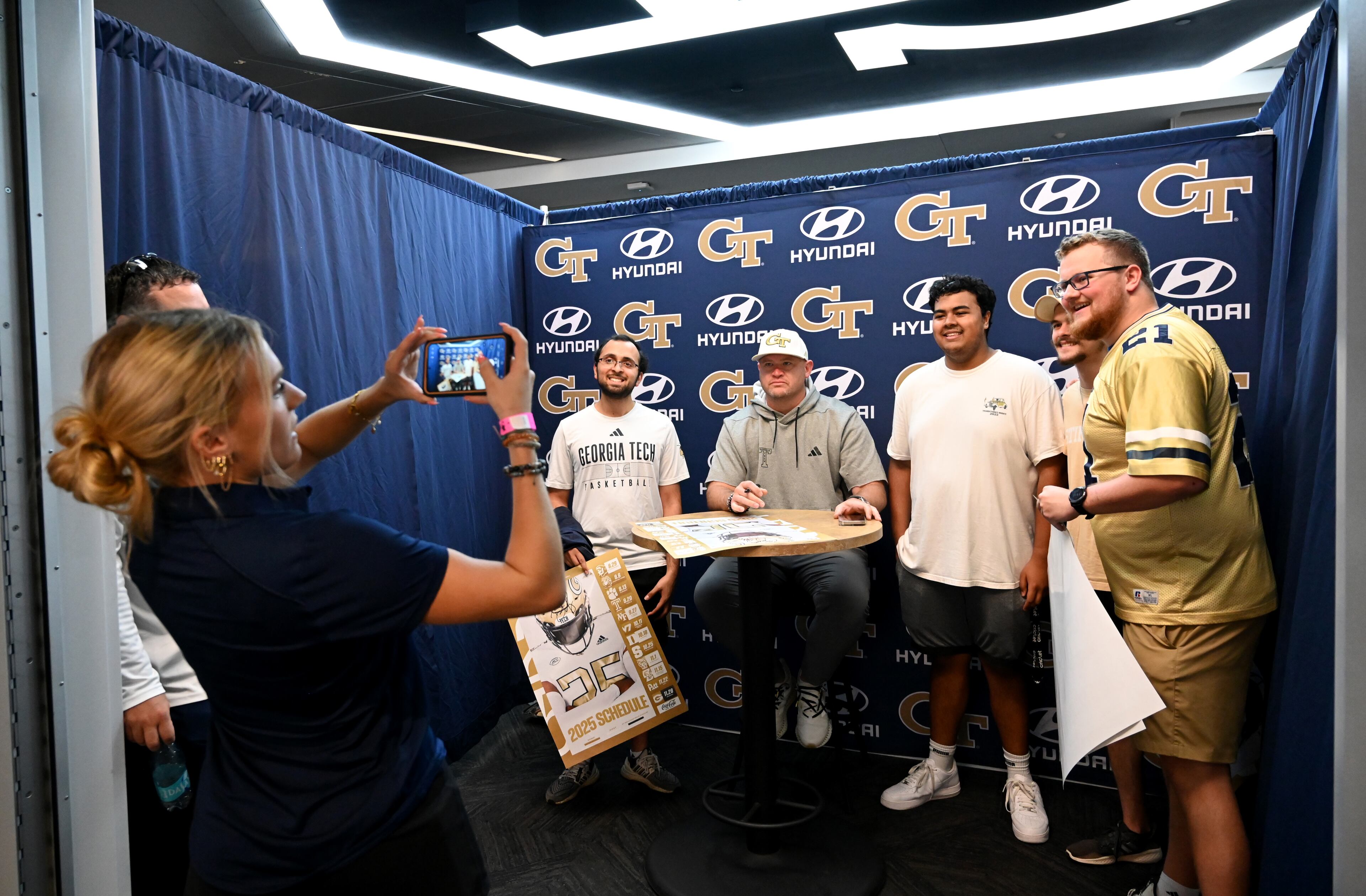 Georgia Tech head coach Brent Key poses with attendees as he signs autographs during the annual “First Saturday on The Flats” at Bobby Dodd Stadium, Saturday, August 2, 2025, in Atlanta. The Flats provides Tech fans with the opportunity to engage with their favorite Yellow Jackets ahead of the upcoming 2025 season. The event offers a variety of entertaining activities for the whole family, including a DJ, autograph opportunities, tailgate games and interactive experiences right on the field at Bobby Dodd Stadium. (Hyosub Shin / AJC)