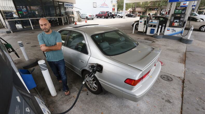 Mark Bagguns buys gas on Highland Avenue in Atlanta in November. Prices this Christmas week will be higher than last year, but about $1 a cheaper than three years ago. BOB ANDRES /BANDRES@AJC.COM