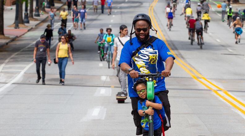 Corey Wills and his son C.J. make their way down Peachtree Street during the Atlanta Streets Alive ride Sunday, April 7, 2019. Atlanta Bicycle Coalition activated 3.1 miles of Peachtree Street for the Sunday afternoon ride.   STEVE SCHAEFER / SPECIAL TO THE AJC