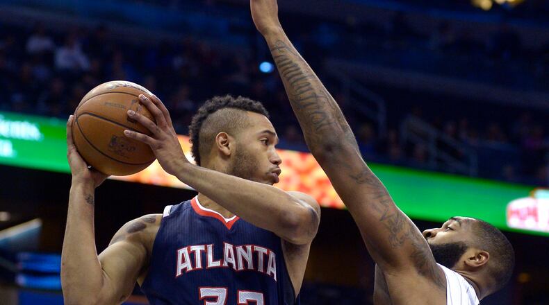 Atlanta Hawks forward Mike Scott (32) looks to pass in front of Orlando Magic forward Kyle O'Quinn during the first half of an NBA basketball game in Orlando, Fla., Wednesday, Jan. 22, 2014.