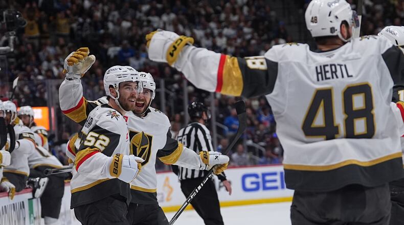Vegas Golden Knights defenseman Dylan Coghlan, front left, is congratulated after scoring a goal by defenseman Shea Theodore, back left, and center Tomas Hertl during the second period in Game 1 of the Western Conference finals NHL hockey Stanley Cup playoff series against the Colorado Avalanche Wednesday, May 20, 2026, in Denver. (AP Photo/David Zalubowski)