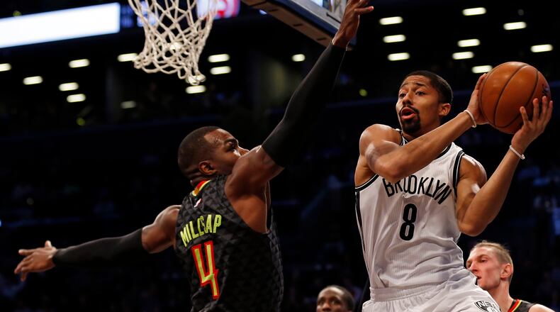 Brooklyn Nets guard Spencer Dinwiddie (8) looks to pass around Atlanta Hawks forward Paul Millsap (4) during the first half of an NBA basketball game Sunday, April 2, 2017, in New York. (AP Photo/Adam Hunger)