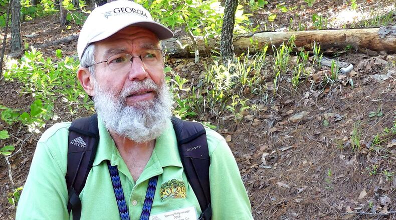 Malcolm Hodges, one of Georgia’s leading lichen experts, describes a lichen growing on a dead tree branch at Sprewell Bluff Wildlife Management Area in Meriwether County. Lichens are made up of two components: a fungus and an alga that function as a single organism in a symbiotic relationship. CHARLES SEABROOK
