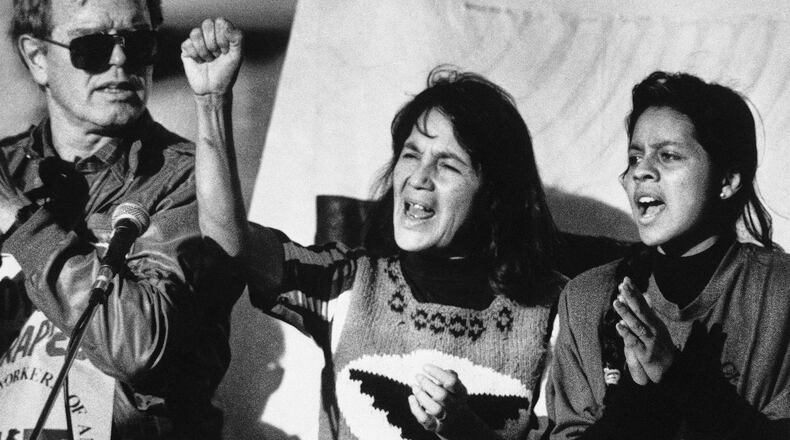 FILE - United Farm Workers leader Dolores Huerta, center, leads a rally in San Francisco's Mission District on Nov. 19, 1988, along with Howard Wallace, president of the San Francisco chapter of the UFW, left, and Maria Elena Chavez, 16, the daughter of Cesar Chavez, right, as part of a national boycott of what the UFW claims is the dangerous use of pesticides on table grapes. (AP Photo/Court Mast, File)