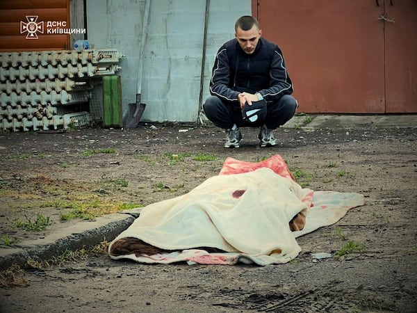 In this photo provided by the Ukrainian Emergency Service, a man reacts at the body of a killed resident following Russia's drone attack in the Kyiv region, Ukraine, Sunday, May 18, 2025. (Ukrainian Emergency Service via AP)