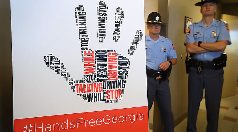 Georgia State Patrol officers, who will be enforcing the law, attend a ceremony where Gov. Nathan Deal signed the Hands-Free Georgia Act. The law is designed to curb distracted driving.