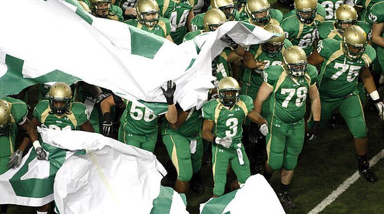 The Buford Wolves crash through a banner to announce their arrival.
