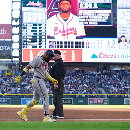 Atlanta Braves' Ronald Acuña Jr., center left, walks gingerly after being injured while running out a groundout as first base umpire Bill Miller, center right, looks on in the second inning of a baseball game against the Colorado Rockies, Saturday, May 2, 2026, in Denver. (AP Photo/David Zalubowski)