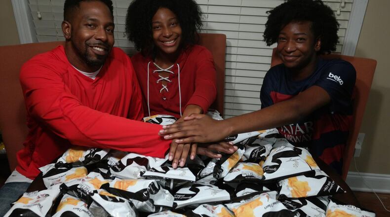 Dondre Anderson (left) and his two daughters, Amari (center) and Amina (right), are owners of one of the world’s few black-owned potato chip companies. CONTRIBUTED BY DONDRE ANDERSON