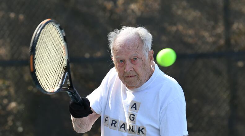 Frank Stovall celebrates his 100th birthday with some singles tennis with his tennis partner Jane Moss. (Hyosub Shin / Hyosub.Shin@ajc.com)