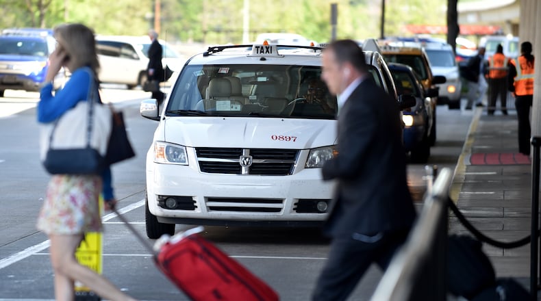 April 22, 2015 Atlanta: These arriving passengers were walking to an airport shuttle at Hartsfield Jackson International Airport, but some passengers are bypassing traditional transportation such as taxis and shuttles, instead opting for the growing popularity of social media based ride services such as Uber. BRANT SANDERLIN/BSANDERLIN@AJC.COM