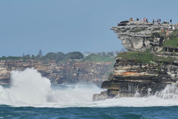 Crowds watch from the headland as large swells hit Sydney's Bondi Beach Wednesday, April 2, 2025. (AP Photo/Mark Baker)
