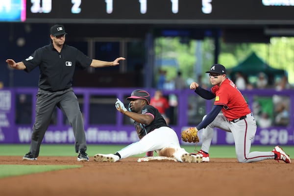 Miami Marlins' Jesus Sanchez, center, safely slides into second base during the third inning of a baseball game against the Atlanta Braves, Saturday, June 21, 2025, in Miami. (AP Photo/Alexandra Rodriguez)