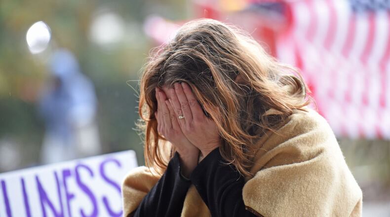 A protester gets emotional as she prays outside the DeKalb County courthouse on Thursday, while awaiting the grand jury’s decision on whether to charge a police officer in the shooting death of a civilian.