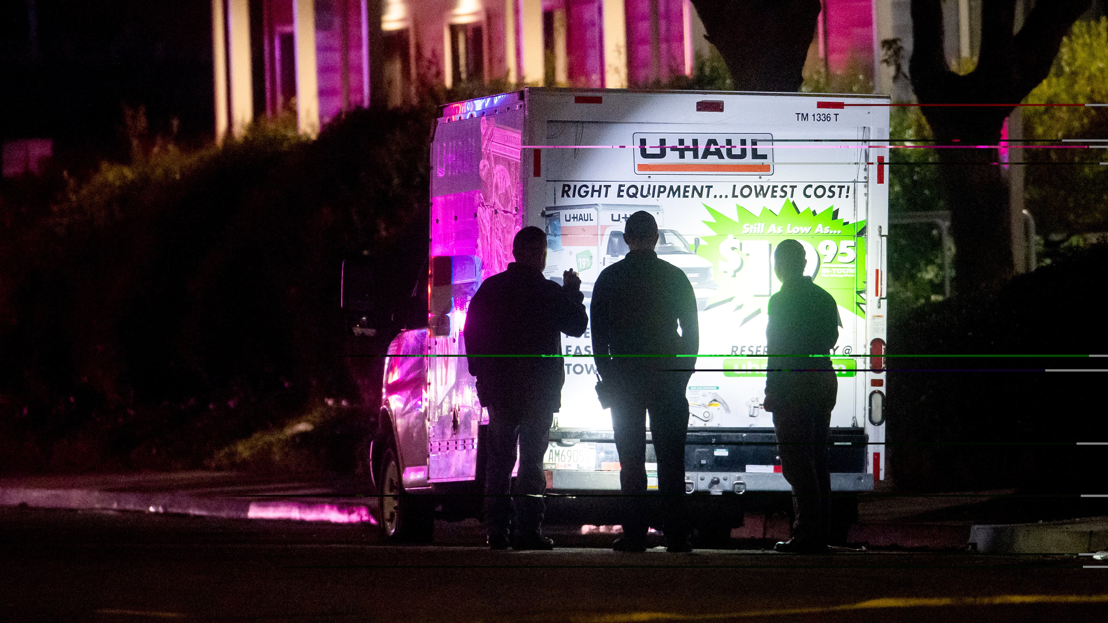 Police officers examine a U-Haul truck involved in a shooting at the entrance to Coast Guard Base Alameda, according to an officer at the scene, on Friday, Oct. 24, 2025, in Oakland, Calif. (AP Photo/Noah Berger)