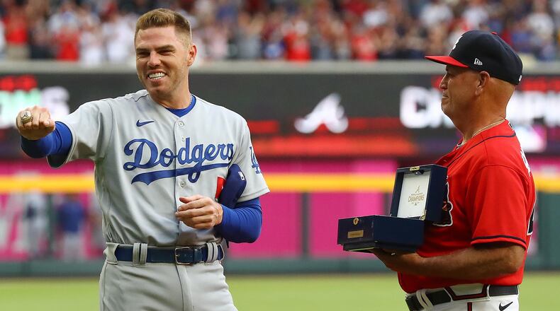 Braves manager Brian Snitker, right, presents former Atlanta Braves first baseman Freddie Freeman his World Series Championship ring, who shows it off to the fans during his ring presentation ceremony as he returns to Atlanta with the Los Angles Dodgers at Truist Park on Friday, June 24, 2022, in Atlanta. The series marks Freeman's first games in Atlanta since the longtime Braves star signed with the Dodgers as a free agent in March. Curtis Compton/Atlanta Journal-Constitution